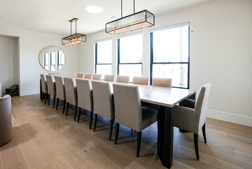 Long wooden meeting table with chairs in a bright room