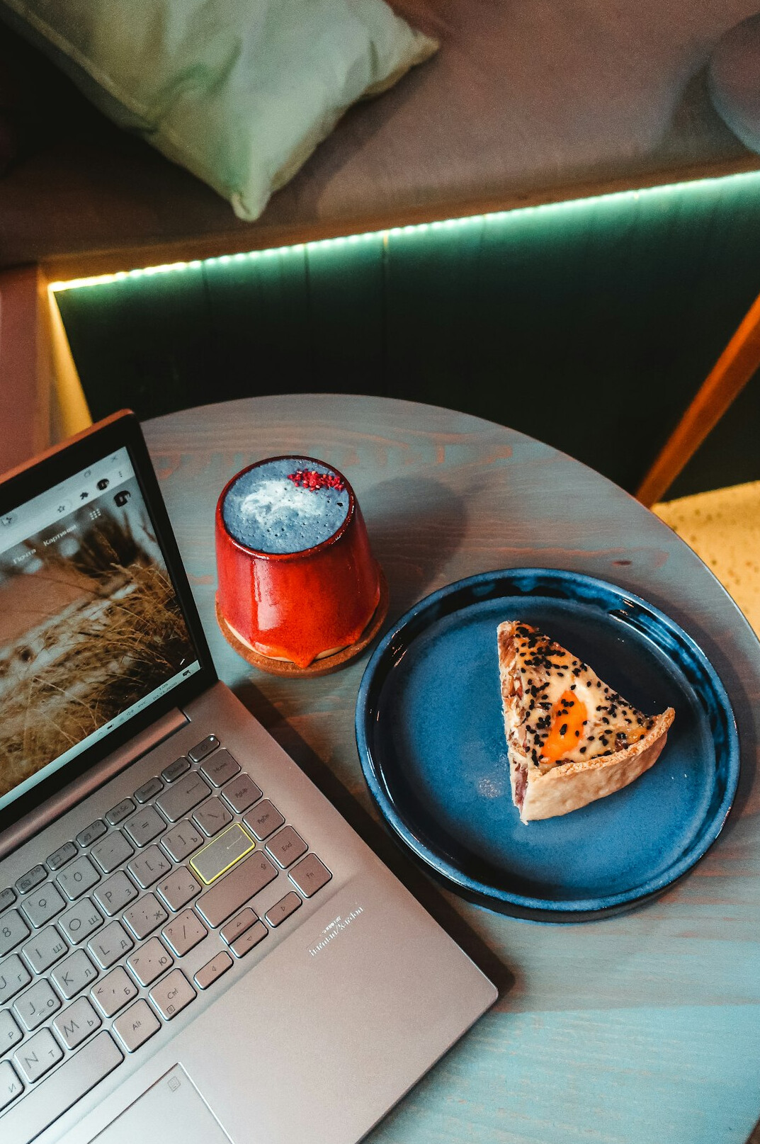 Top view of a desk with a laptop, notebook and coffee cup